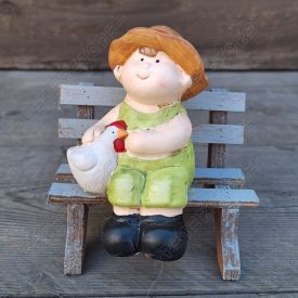 Kisfiú csirkével padon ülő figura